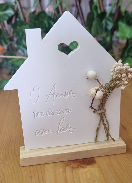 Placa decorativa em forma de casa branca com abertura em coração e frase