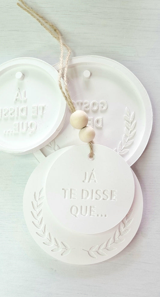Molde circular branco com mensagem em relevo “JÁ TE DISSE QUE…” e coroa de louros