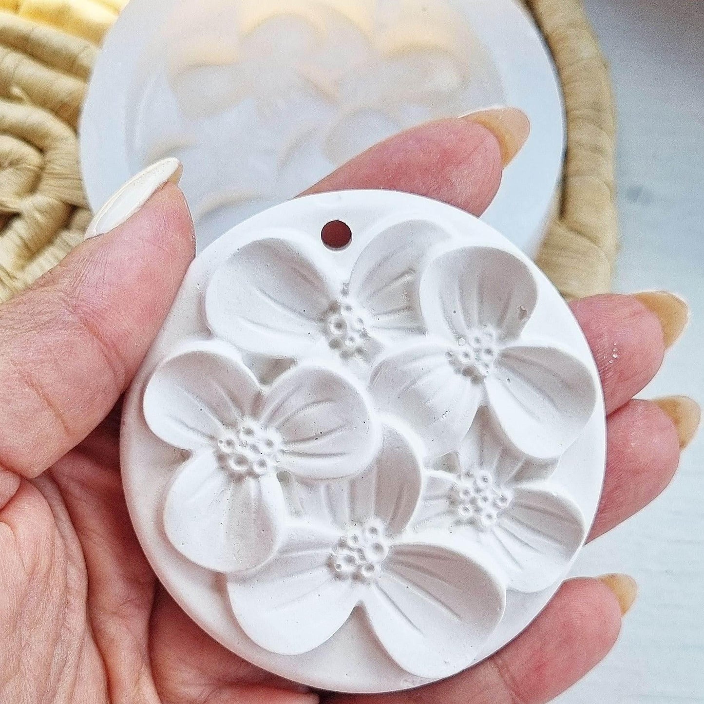 Molde redondo de silicone com flores em relevo e marca circular no topo