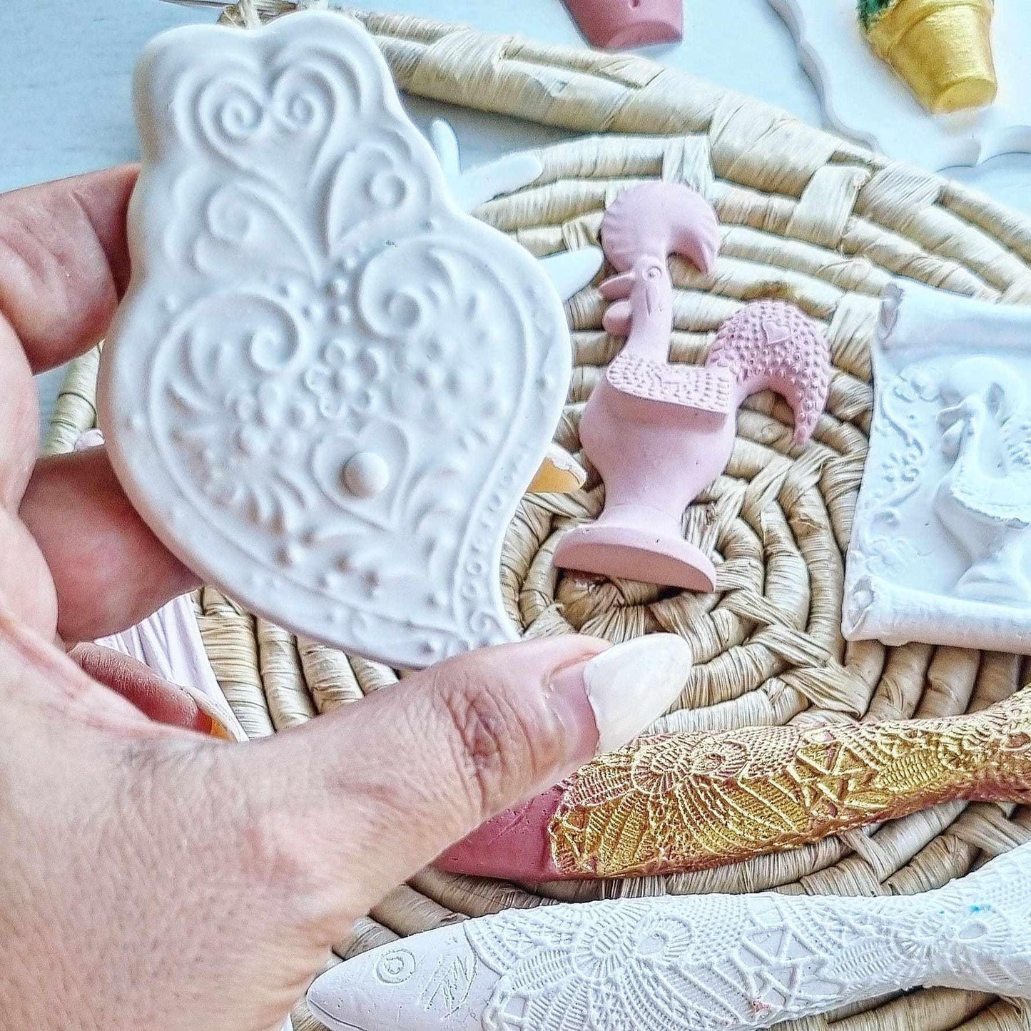 Molde de coração branco com relevo, mão a segurar peça decorativa