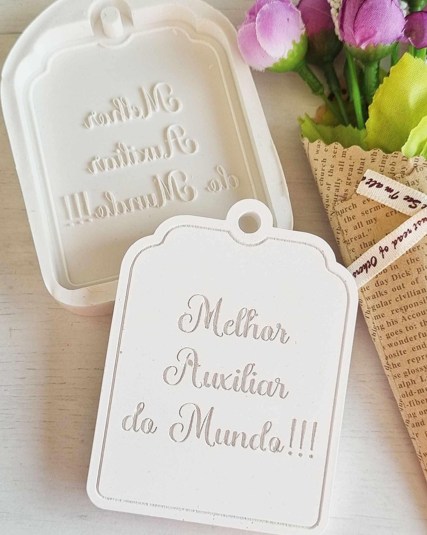 Molde branco em forma de etiqueta com texto “Melhor Auxiliar do Mundo”