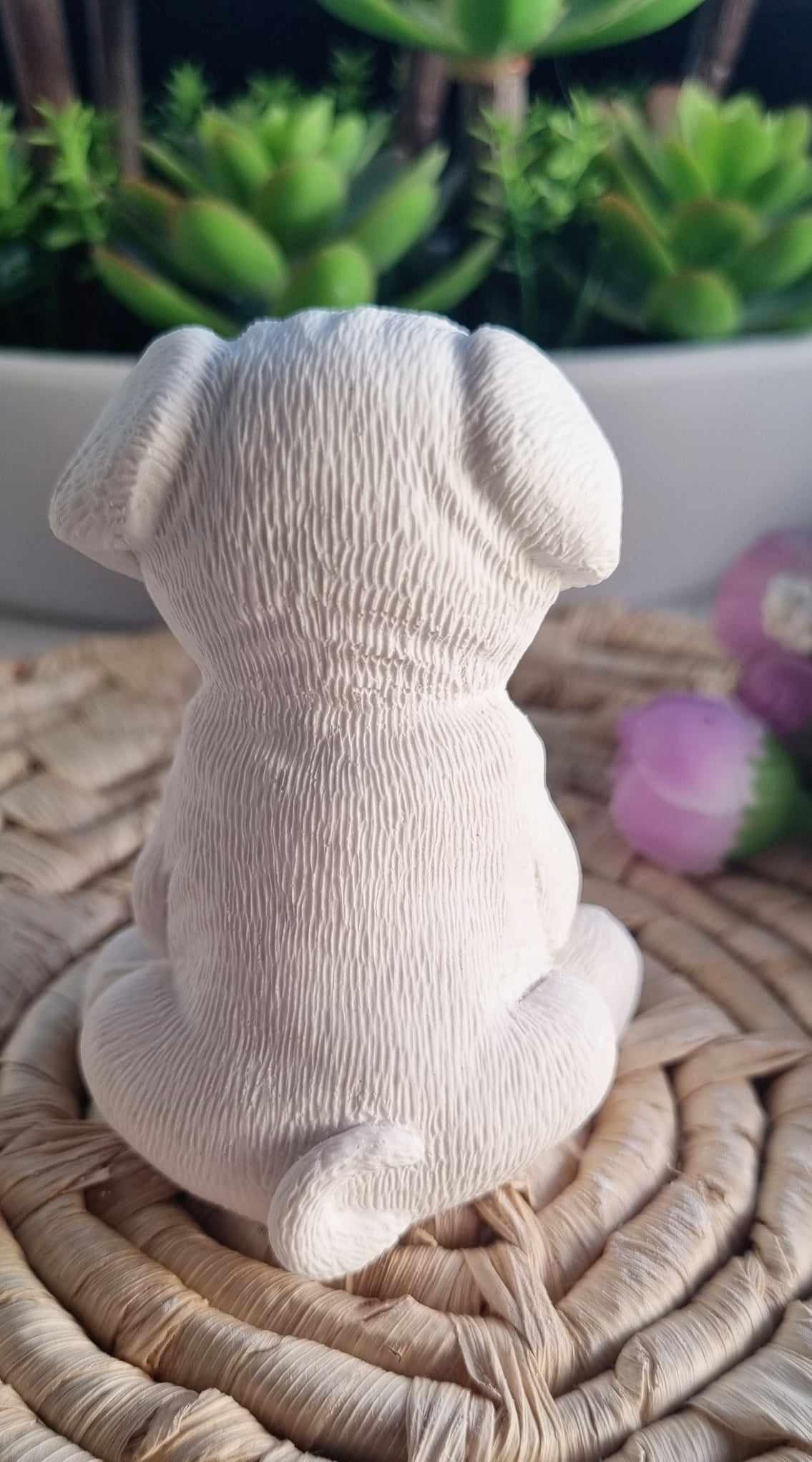 Molde em forma de bulldog branco, cão sentado visto de costas com textura marcada