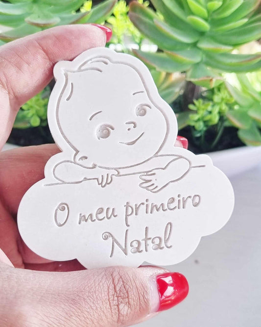 Molde branco em formato de bebé sorridente com a inscrição “O meu primeiro Natal”