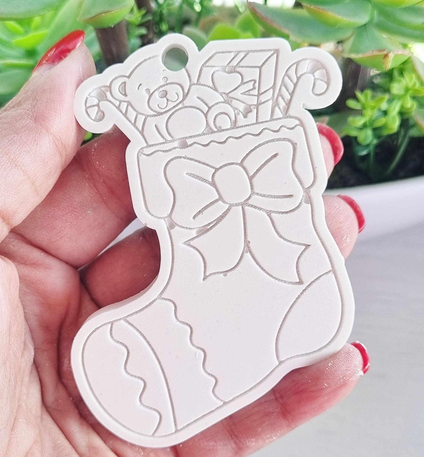 Molde de botinha de Natal branco com urso e laço, visto na mão