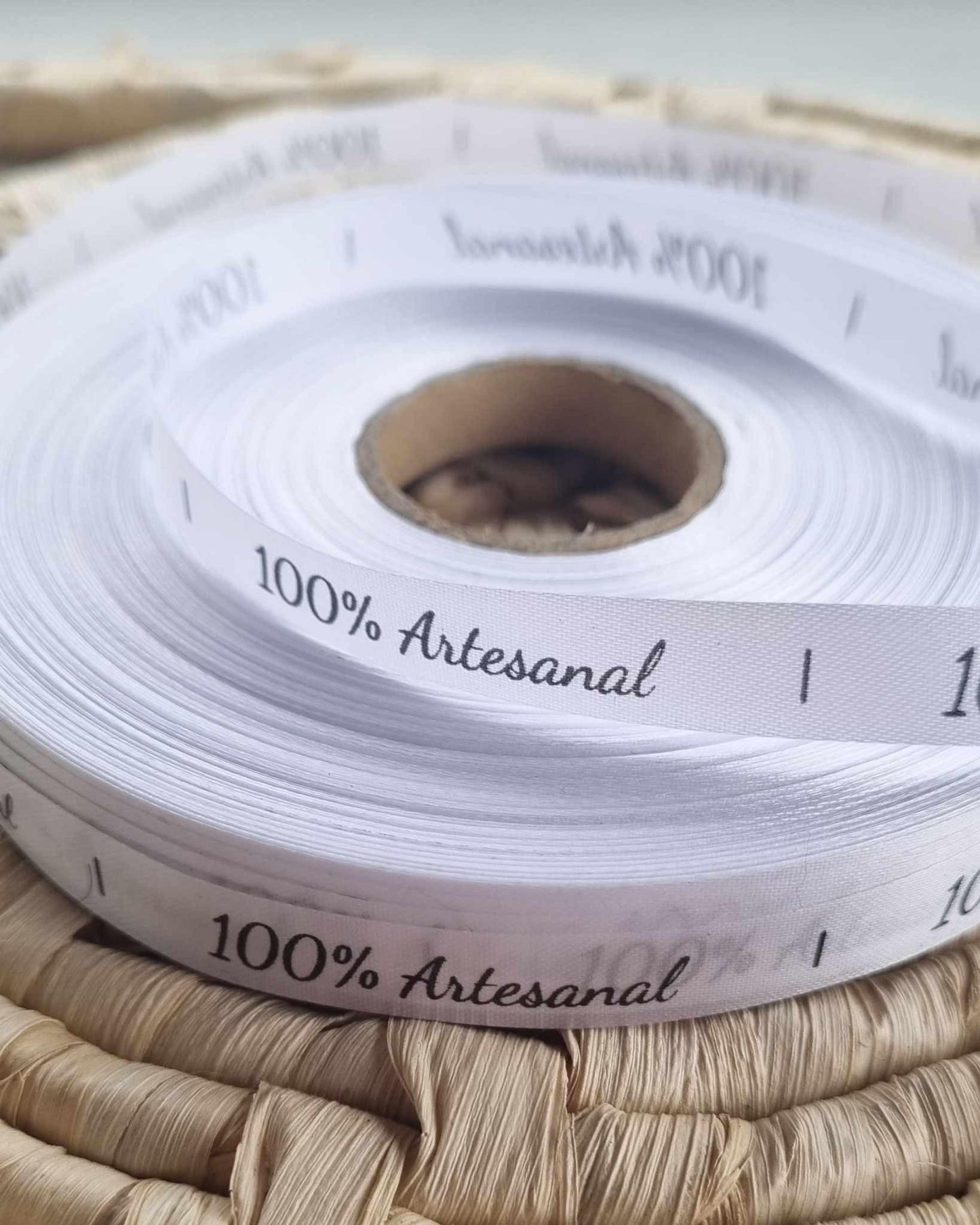 Fita branca com texto “100% Artesanal”, em rolo