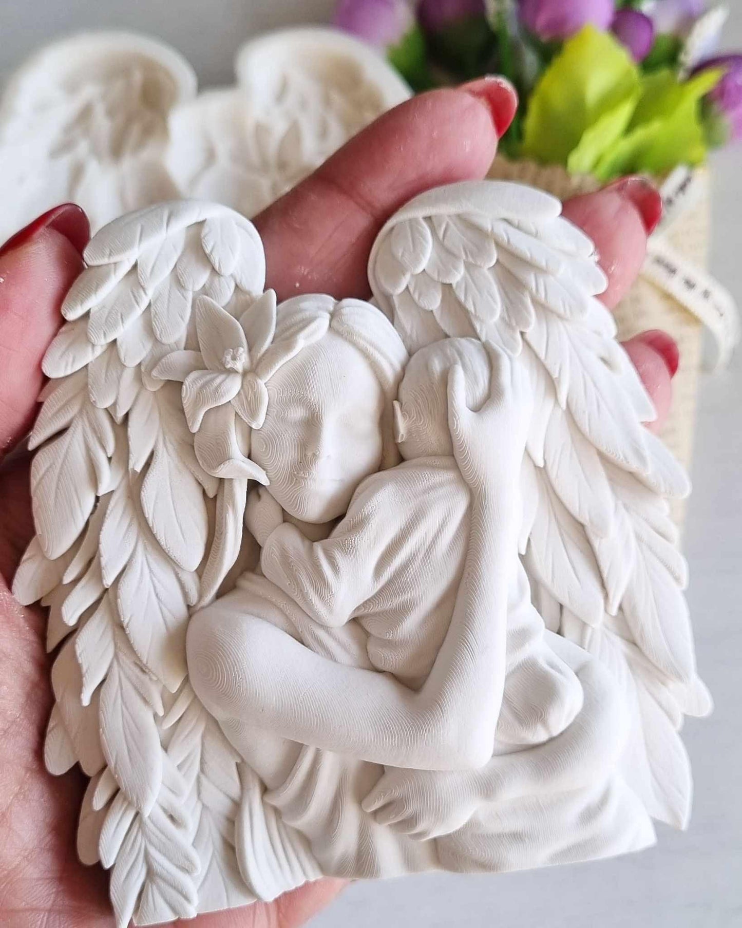 Decoração branca de anjo: asas com pétalas e bebé esculpido, vista de perto