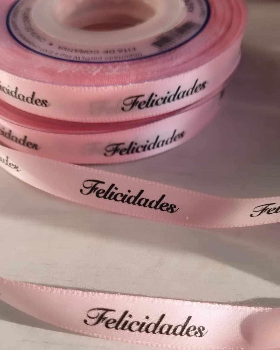 Fita decorativa rosa com texto 'Felicidades'