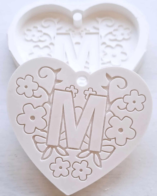 Molde em forma de coração com relevo da letra M e flores decorativas