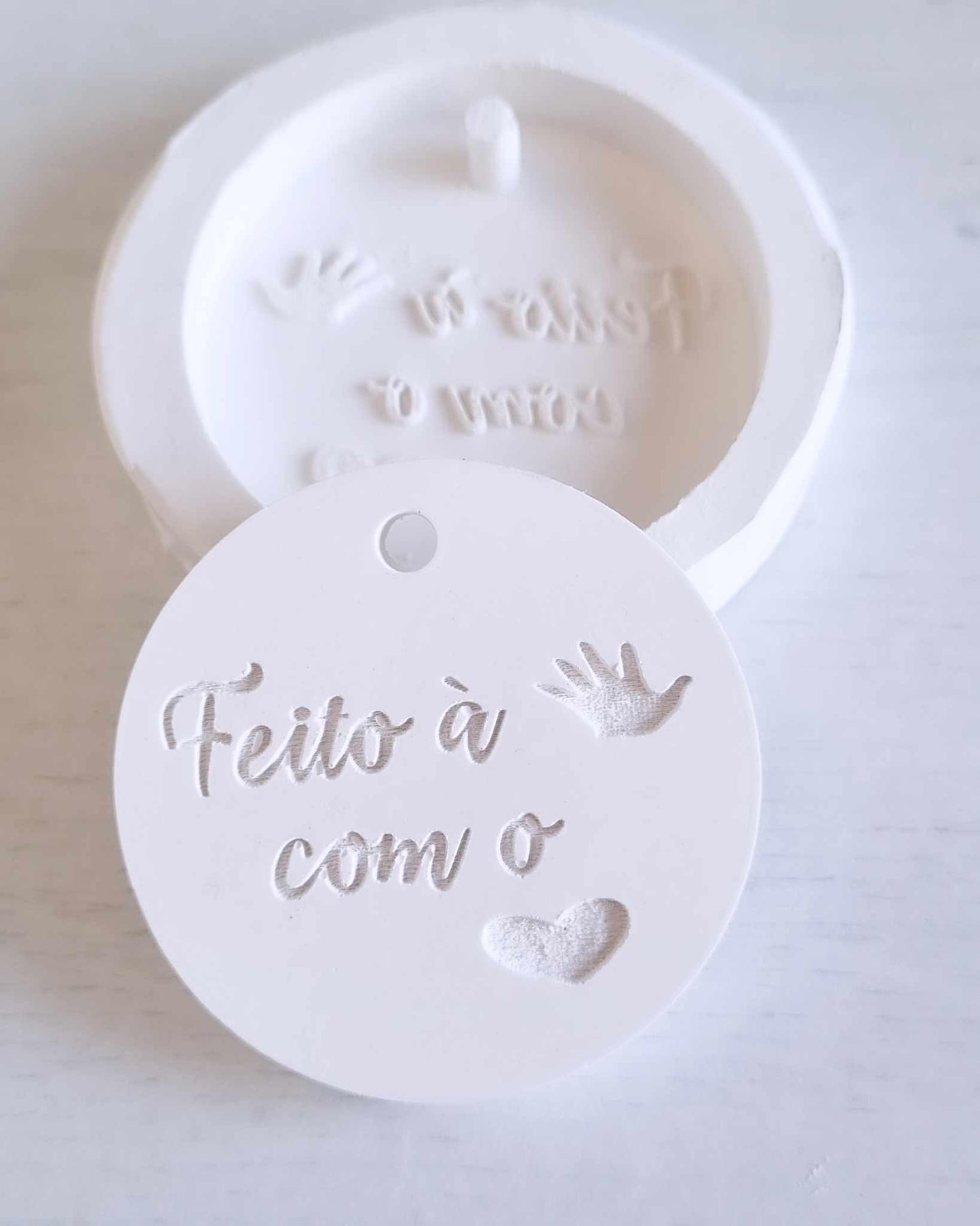 Molde circular branco com 'Feito à mão' e ícones de mãos e coração