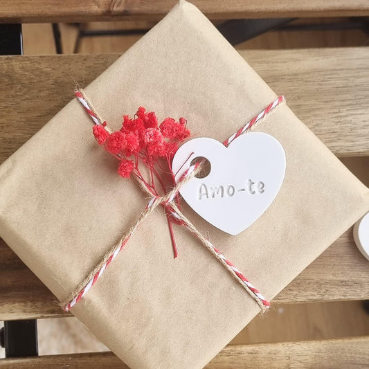 Etiqueta em coração branco com o texto “Amo-te” num embrulho kraft com cordel
