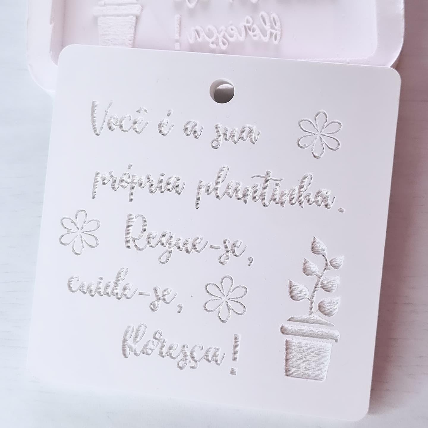 Molde de mensagem inspiradora em cartão branco com texto e flores em relevo