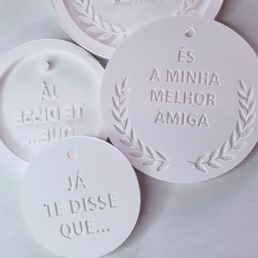 Conjunto de duas etiquetas redondas brancas, com frases em relevo