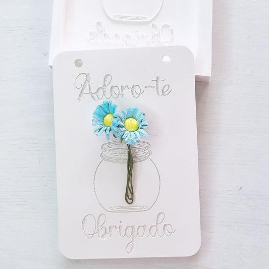Molde de cartão branco com vaso, flores azuis e dedicatória «Obrigado»