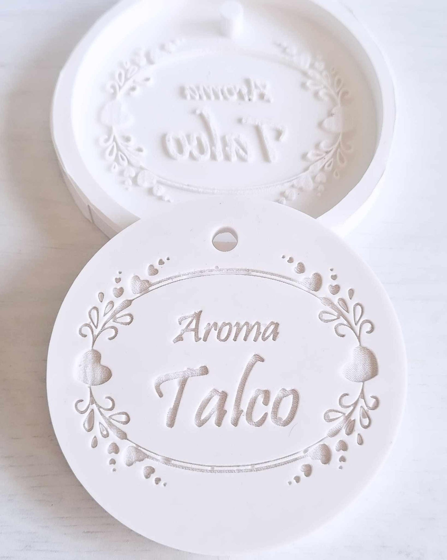 Molde circular branco com relevo “Aroma Talco” e motivos florais