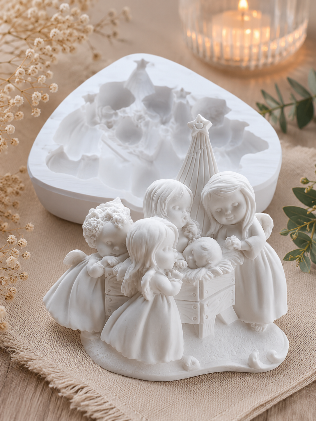 Molde branco com anjos à volta de uma árvore, com figuras em relevo
