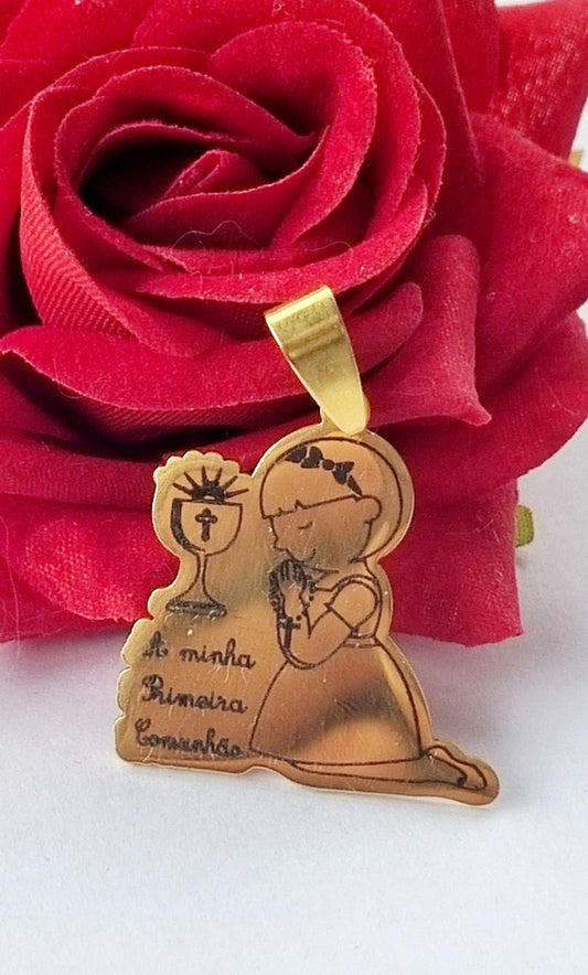 Medalha dourada de primeira comunhão com menina sentada e cálice em relevo