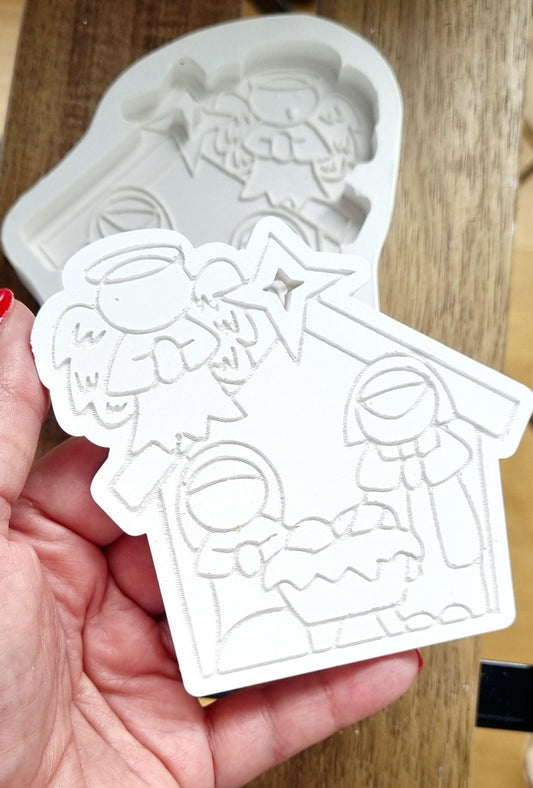 Molde de presépio branco em forma de cabana com figuras e furo em estrela.