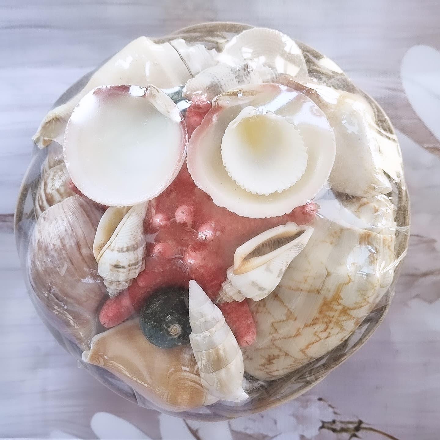 Cesta pequena decorada com conchas brancas e elementos rosa