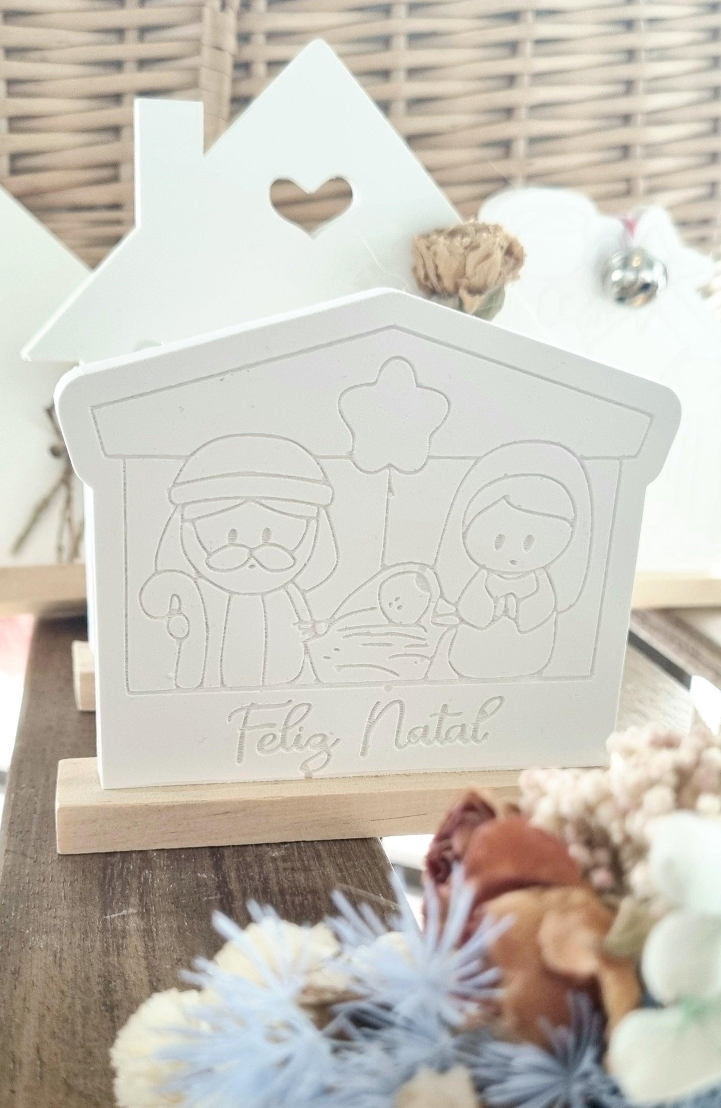 Molde branco em forma de cabana, relevo do presépio e texto “Feliz Natal”