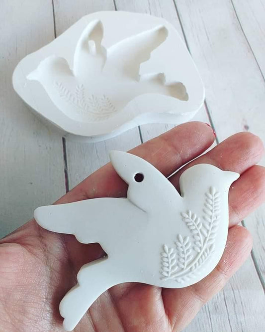 Molde de pomba branco com espigas em relevo, segurado na mão