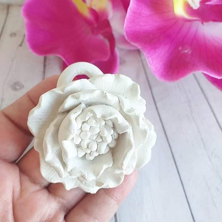 Molde de flor branco em relevo, com furo central circular