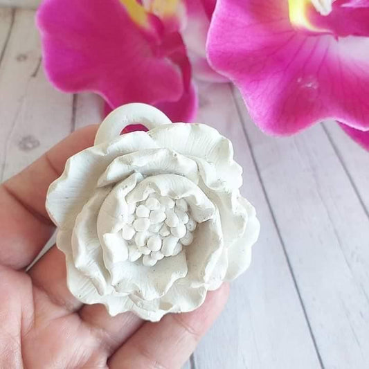 Molde de flor branco em relevo, com furo central circular