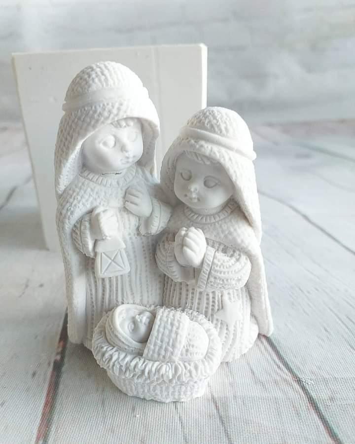 Presépio em croché 3D branco com duas figuras segurando um bebé