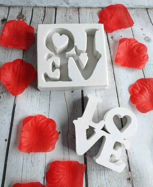 Molde de silicone branco com letras “LOVE” e coração, com corações vermelhos ao redor.