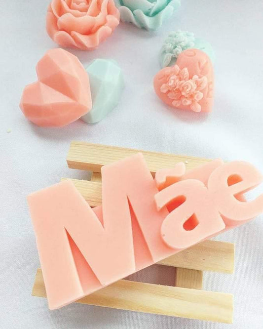 Molde de letras “Mãe” rosa sobre base de madeira