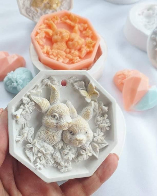 Molde de coelhos com furo, coelhos em relevo no molde branco, em mão