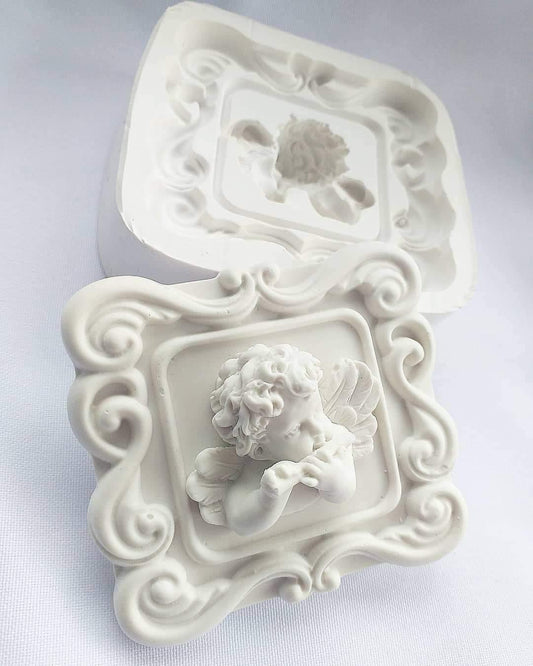 Molde branco com anjo em relevo dentro de moldura decorativa