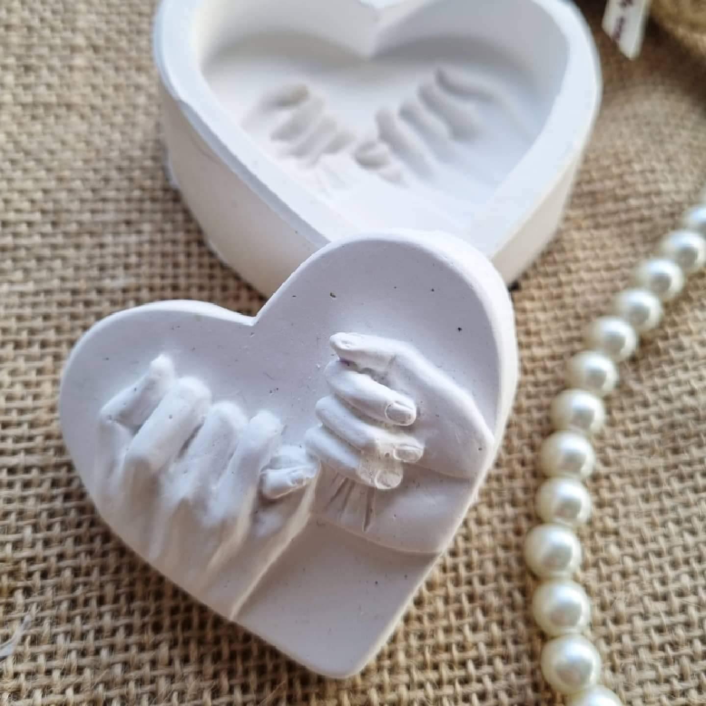 Molde em forma de coração branco com relevo de mãos