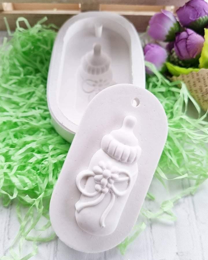Molde de silicone branco para biberão, com figura em relevo e flor.