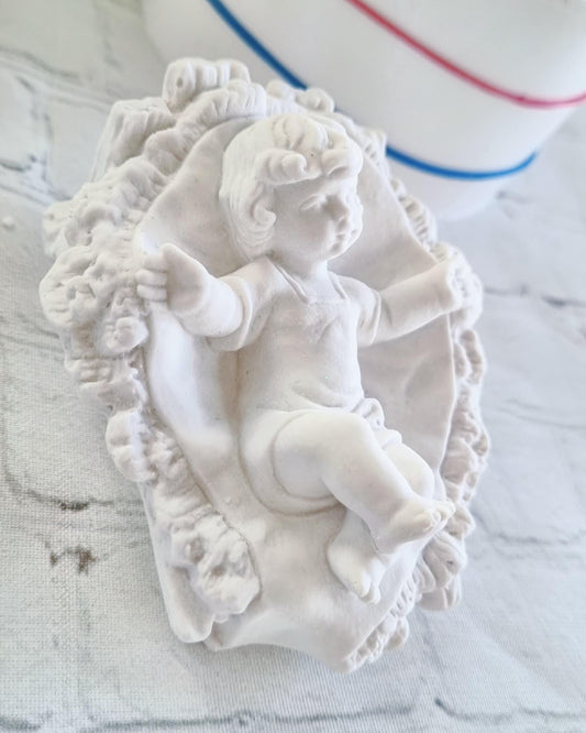 Molde grande do menino Jesus em relevo, com palhas ornamentais e manto branco