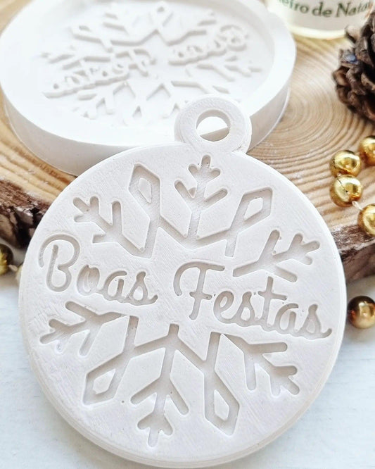Molde branco em silicone com floco de neve e inscrição “Boas Festas”.