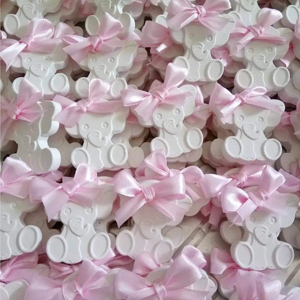 Elefantes brancos decorativos com laços rosa em fitas de cetim