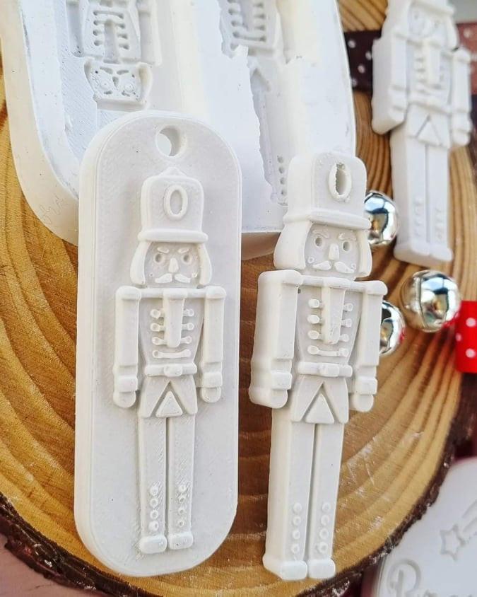 Molde branco com duas figuras de soldadinhos de chumbo, em relevo e pormenores