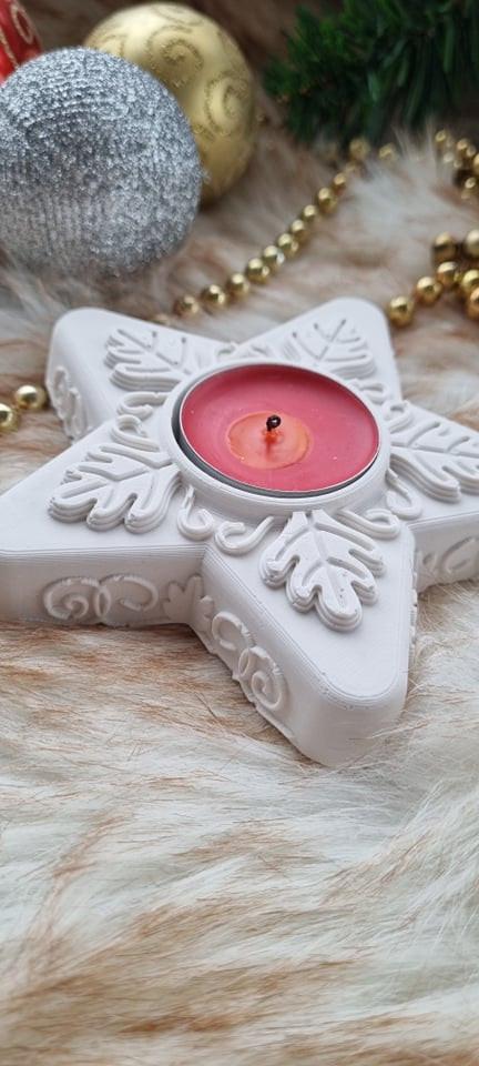 Molde porta-vela em estrela branca com vela de cor rosa e aro metálico