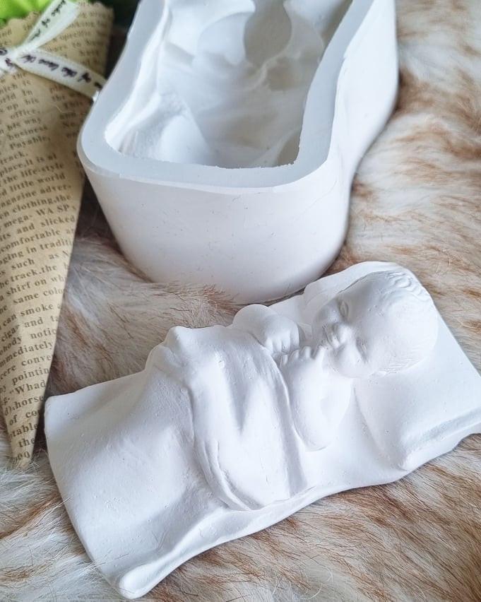 Molde de bebé com manta branca e peça para os pés