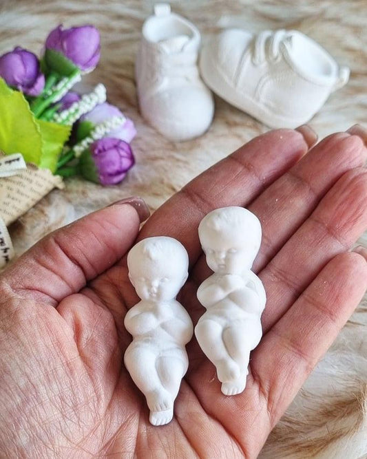 Molde para bebé a dormir pequeno: dois bonecos brancos na palma da mão.