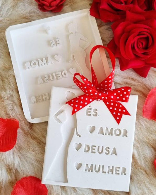 Molde branco com figura e letras “AMOR”, “DEUSA” e “MULHER”, com laço vermelho