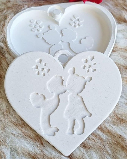 Molde de coração branco com relevo de dois bonecos e detalhes florais