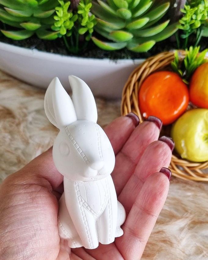 Molde 3D de coelho branco, segurado na mão, com orelhas e corpo em relevo