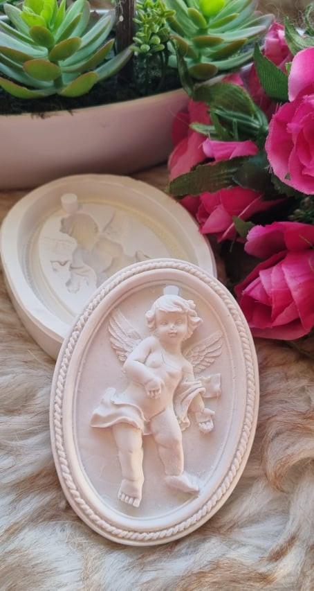 Placa oval decorativa com anjo em relevo e rebordo, tom creme