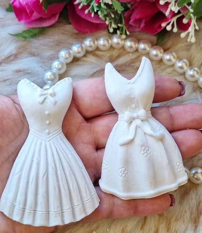 Molde duplo de vestidos brancos em mão, com laço e detalhes florais