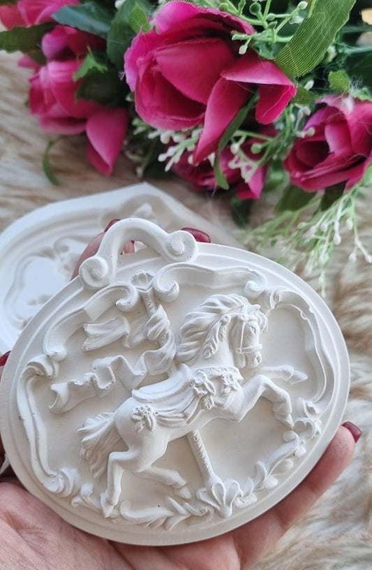 Molde oval de cavalo em relevo branco, segurado na mão, com detalhe decorativo