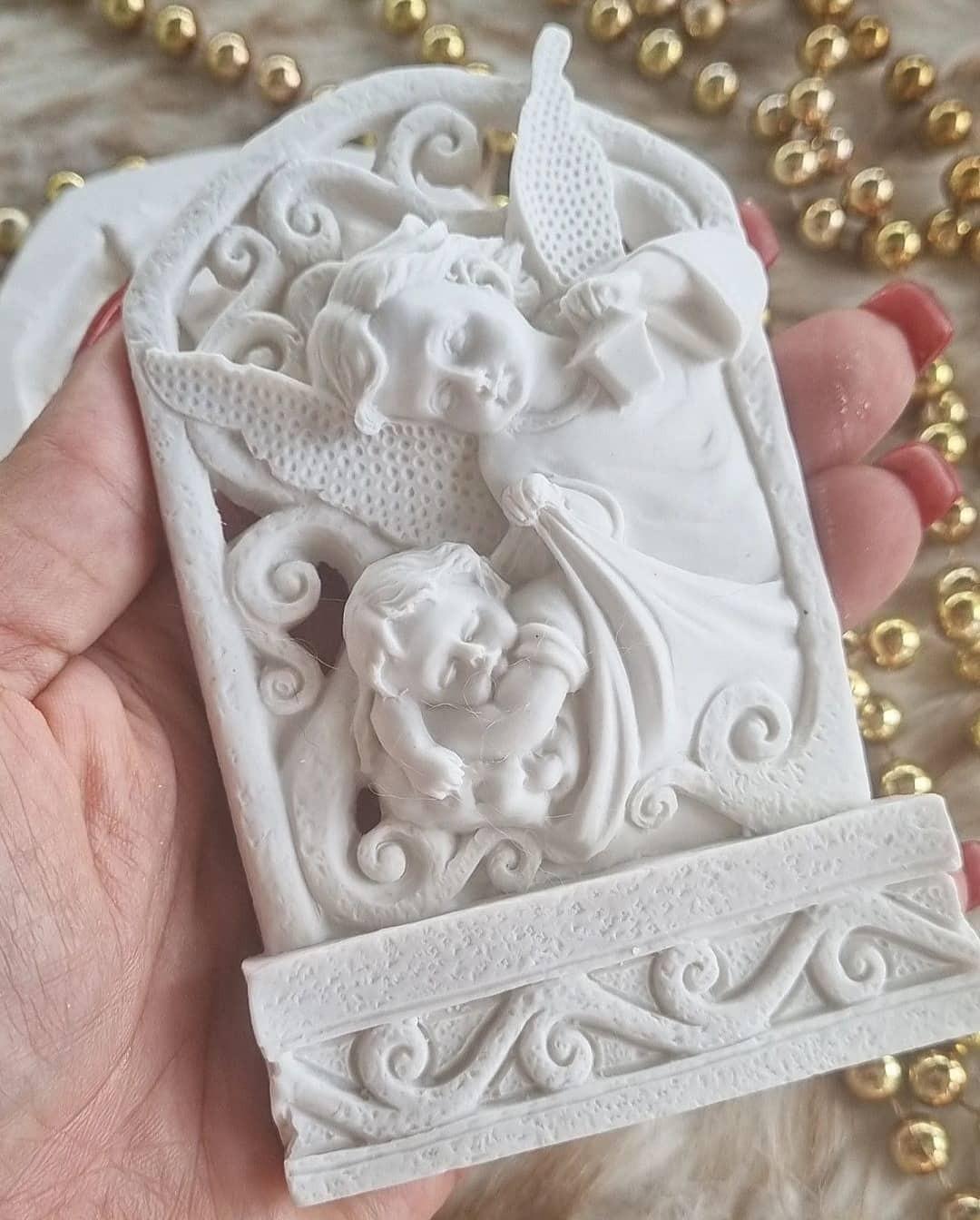 Molde decorativo em relevo com anjo da guarda e bebé, visto em mão, branco