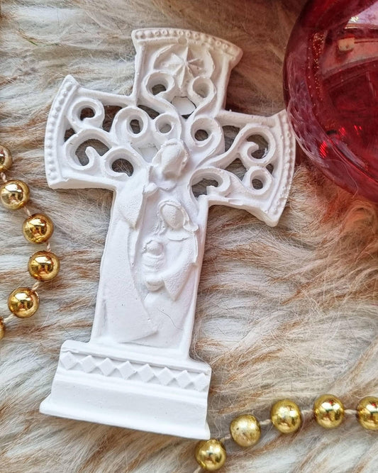 Cruz decorativa branca com padrão em relevo e círculos vazados