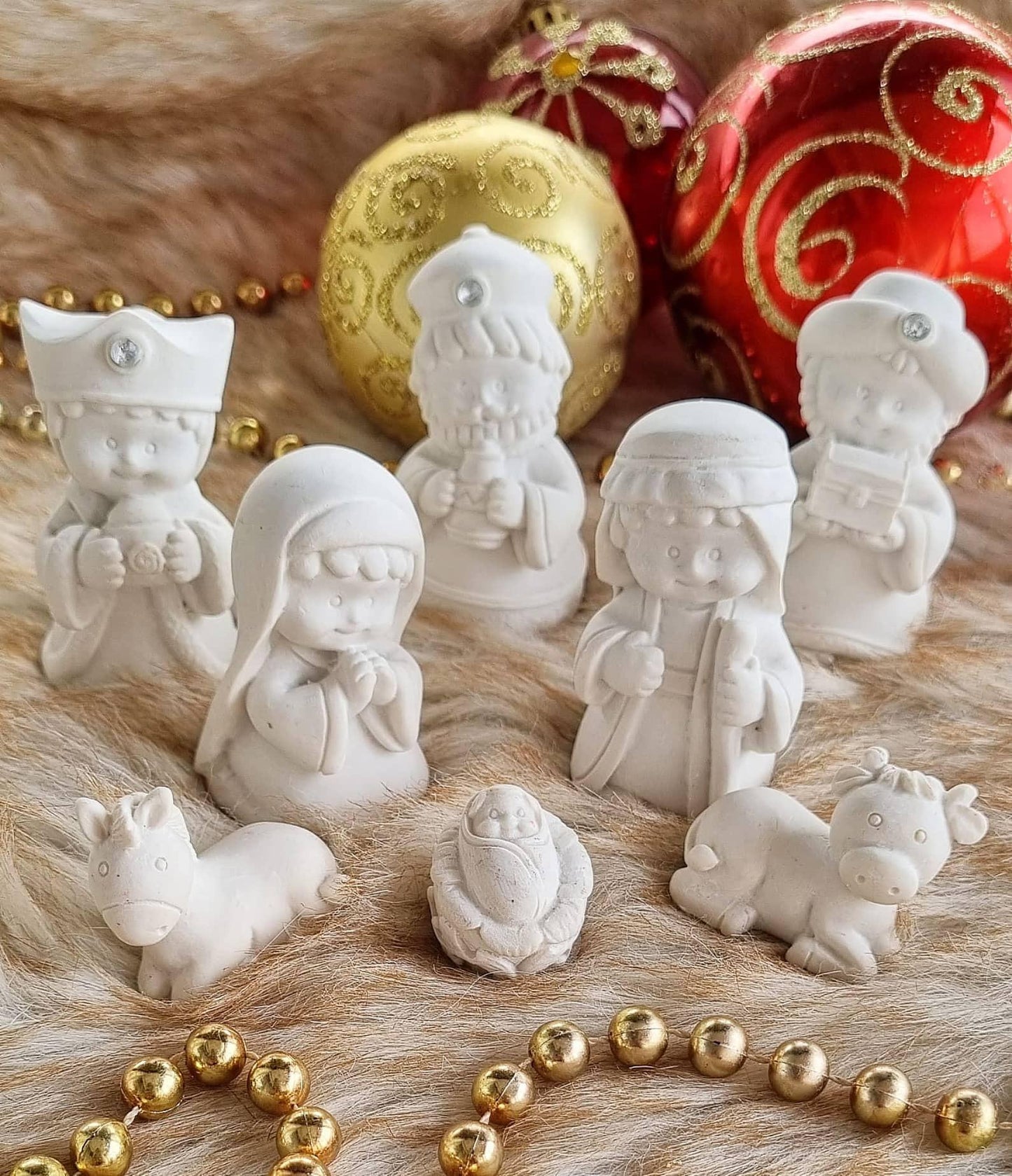 Figuras do presépio em moldes brancos: Reis Magos e animais, com detalhes