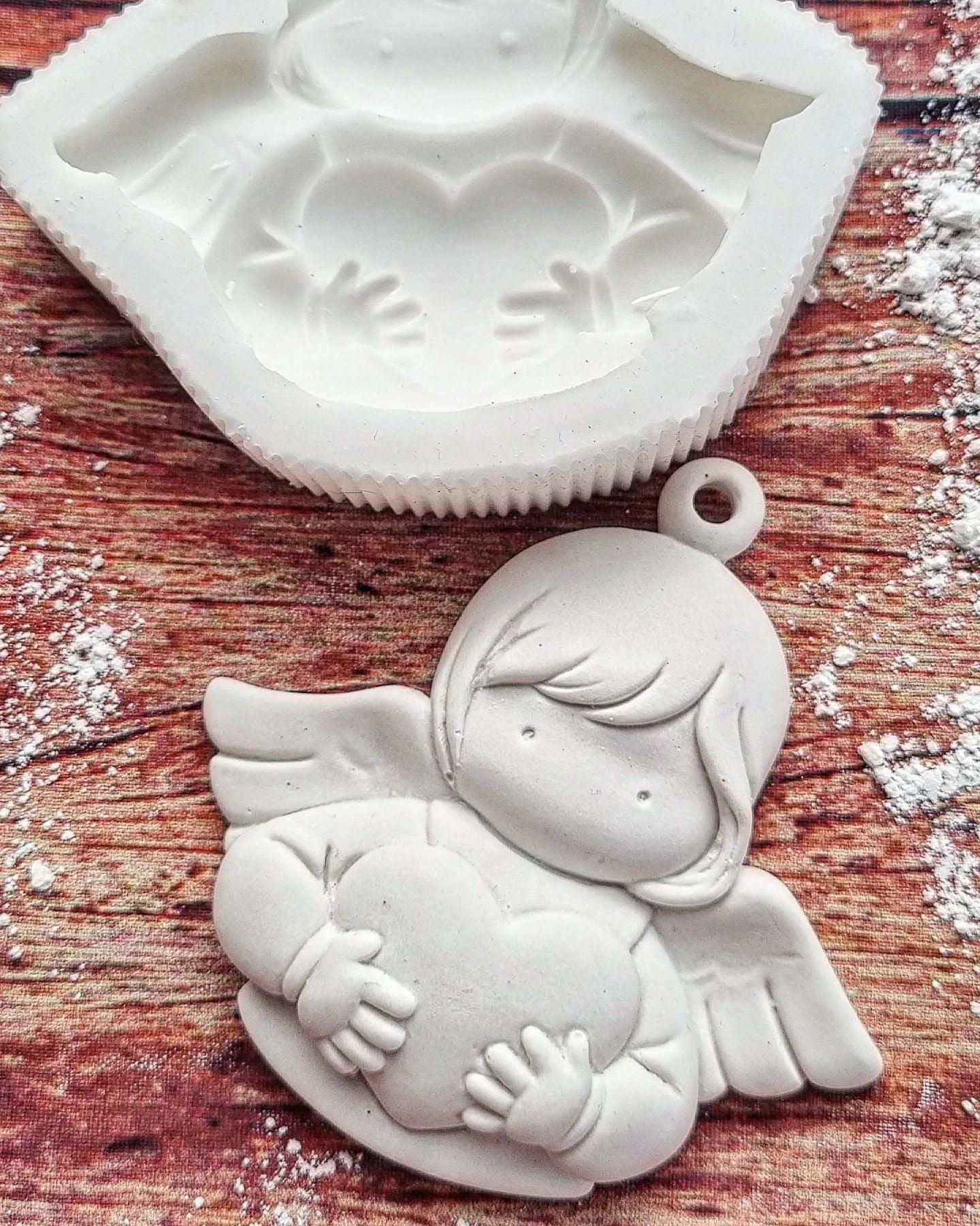 Molde de anjo branco com argola e coração; cavidade do molde ao lado